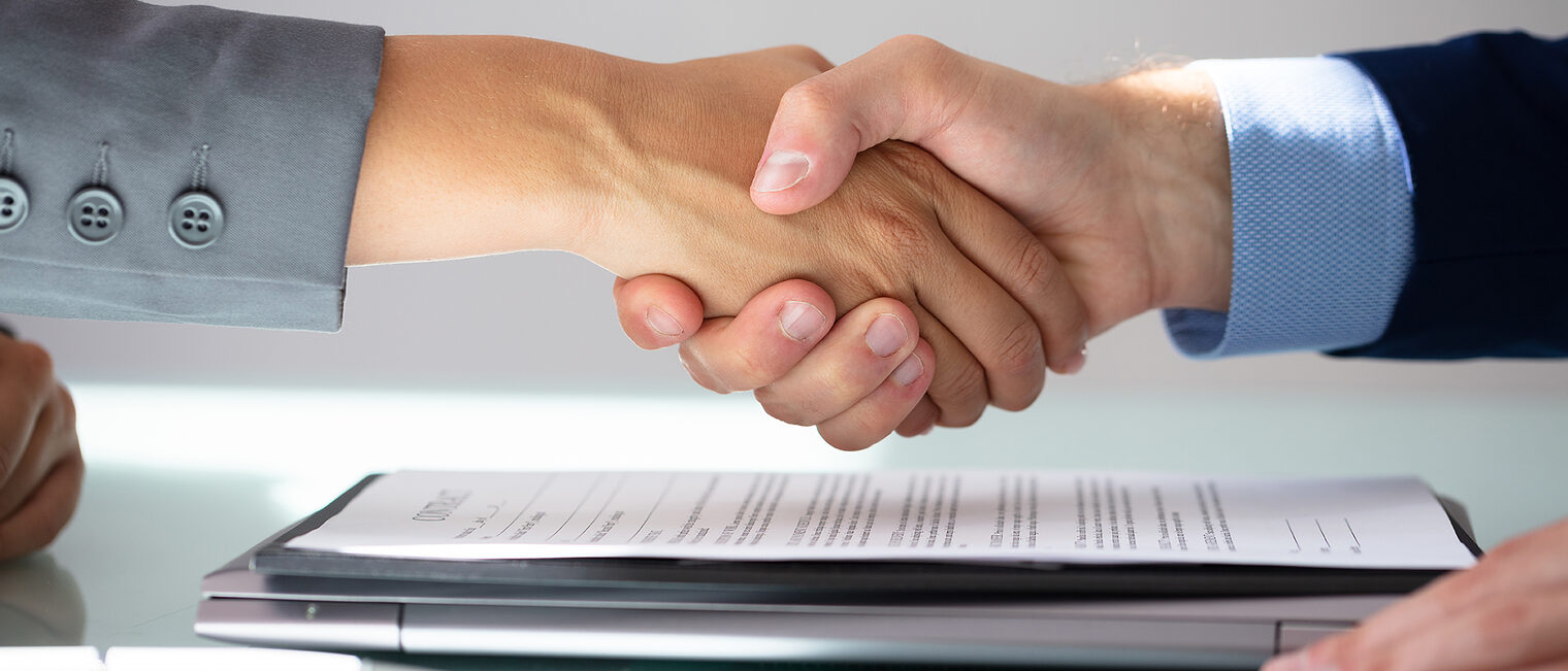 Business Partners Shaking Hands Over Contract Form