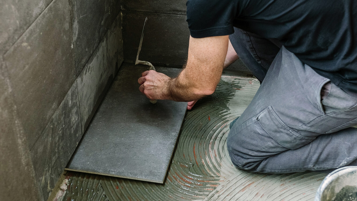 Workman laying a new tile floor on a terrace Schlagwort(e): mason, reform, laying, tile, light knocks, spatula, tap, glazed terrace, handyman, banner, web, header, panorama, panoramic, unrecognizable, placing, diy, workman, concrete, tiling, floor, maintenance, manual worker, working, terrace, construction, man, tool, imitation cement tile, cement, tiler, installing, repairing, male, interior, renovation, indoor, material, masonry, equipment, tiled, person, caucasian, people, one, cube, screed, builder, preparing, horizontal, mason, reform, laying, tile, light knocks, spatula, tap, glazed terrace, handyman, banner, web, header, panorama, panoramic, unrecognizable, placing, diy, workman, concrete, tiling, floor, maintenance, manual worker, working, terrace, construction, man, tool, imitation cement tile, cement, tiler, installing, repairing, male, interior, renovation, indoor, material, masonry, equipment, tiled, person, caucasian, people, one, cube, screed, builder, preparing, horizontal