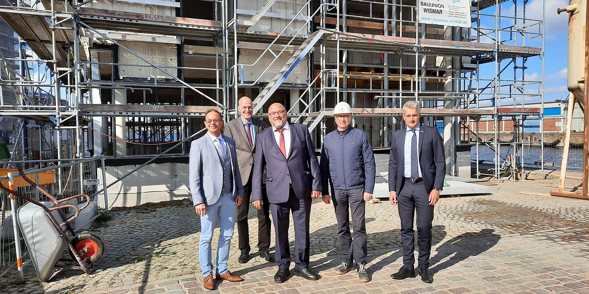Die Delegation auf einer aktuellen Baustelle der Bauunion Wismar im Hafen Wismars. Die Spitzen aus Wirtschaftsministerium und Handwerkskammer Schwerin unterwegs im Kammerbezirk.