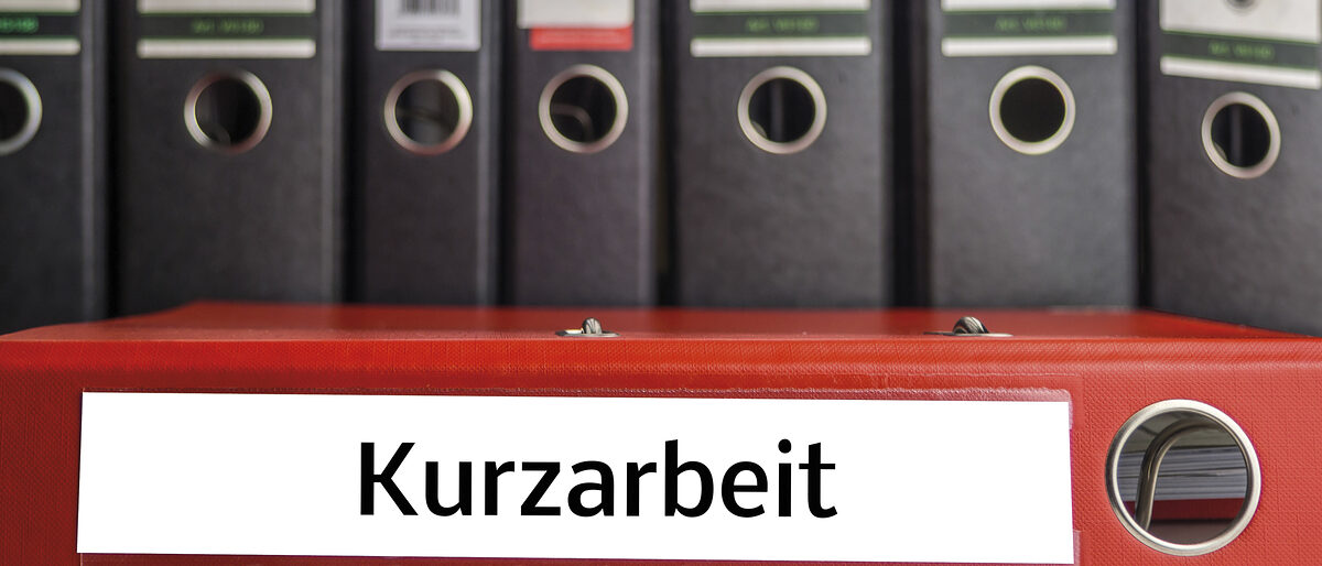 Aktenordner mit der Aufschrift ¿Kurzarbeit¿ liegt quer im Bild. Im Hintergrund stehen schwarze Aktenordner. Schlagwort(e): deutsch, icon-image, kurzarbeit, ordner, arbeit, recht, schnell, krisis, wirtschaft, gesellschaft, bewerbung, Deutsch, Deutschland, virus, Staat, bankrott, Laender, retten, regierung, politik, aktenmappe, Finanzierung, Investitionen, Fonds, arbeitslos, Korona, Pandemie, quarantaene, Bundesregierung, kleinunternehmen, Arbeitsmarkt, Symbol Bild, Wirtschaftskrise, Symbolfoto, Kurzarbeit, Dateiordner, Globale Wirtschaftskrise, Arbeitsamtes, Schutzschild, Haertefall, Einzelfirma, COVID-19, covid, liquidity protection, isolvent, hardship fund, sh