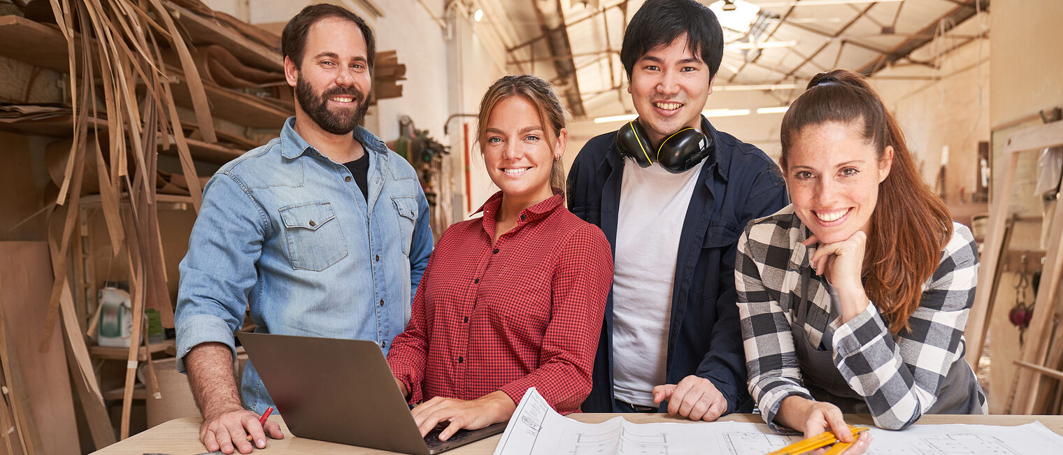 Junges Handwerker Start-Up Team mit Laptop Computer in der Schreinerei Werkstatt Schlagwort(e): Team, Handwerker, Zusammenarbeit, Start-Up, Handwerk, Besprechung, Ausbildung, Planung, Betrieb, mittelständisch, Mittelstand, Gründer, Handwerksbetrieb, positiv, Schreiner, Gruppe, Firma, Computer, Laptop, Internet, Auftrag, online, digital, Schreinerei, Zimmerei, Tischler, Mann, Frau, Arbeit, Beruf, Plan, Bauzeichnung, Bauplan, planen, Kollegen, Lehrling, Bau, Werkstatt, Arbeiter, Holzverarbeitung, Tischlerei, arbeiten, lernen, Lehre, zusammen, Leute
