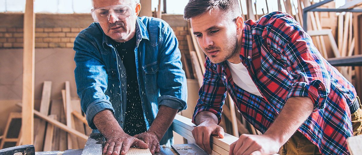 carpenter, carpentry, craftsperson, cutting, circular saw, rotary blade, construction industry, manual worker, men, art and craft, business, working, craft, workshop, indoors, only men, wood, protective eyewear, casual clothing, expertise, plank, skill, small business, work tool, workbench, machinery, males, sawdust, human body part, holding, protective work wear, mature adult, active seniors, adult only, repairman, family business, experience, close up, concentration, young adult, looking, professional occupation, maintenance engineer, carpenter tools, coffee, team, learning