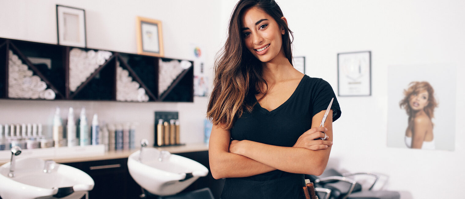 Female hairdresser in salon holding scissors in hand. Smiling young hairdresser standing in salon. Schlagwort(e): arms crossed, barber shop, beautician, beauty, beauty salon, business, dresser, equipment, expertise, fashion, female, hair, hair salon, hairdresser, hairstylist, holding, indoors, looking, mirror, occupation, parlor, portrait, professional, salon, scissors, smiling, staff, standing, studio, stylist, tool, woman, young, woman, hair salon, hairstylist, hairdresser, salon, arms crossed, barber shop, beautician, beauty, beauty salon, business, dresser, equipment, expertise, fashion, female, hair, holding, indoors, looking, mirror, occupation, parlor, portrait, professional, scissors, smiling, staff, standing, studio, stylist, tool, young