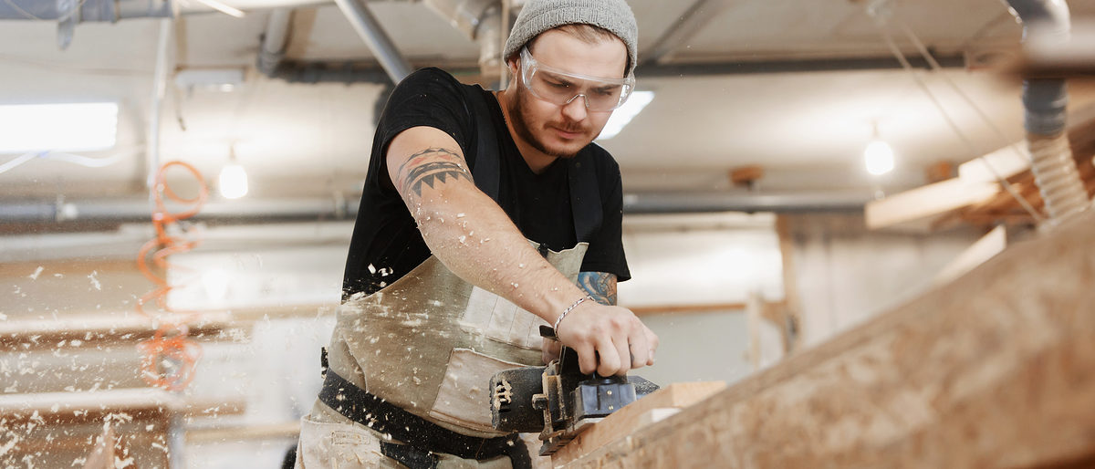Carpenter working with electric planer on wooden plank in workshop. Hands and planer close up. Schlagwort(e): people, planer, carpenter, workshop, furniture, work, wooden, woodworker, woodworking, manufacture, wood, maker, diy, woodshop, machine, electric, shop, woodwork, cabinet, industry, timber, carpentry, caucasian, craft, craftsman, equipment, handmade, hand, holding, improvement, instrument, lumber, men, occupation, one, person, plane, planks, powertool, profession, professional, rasping, sawdust, scobs, tools, workbench, worker, workman, people, planer, carpenter, workshop, furniture, work, wooden, woodworker, woodworking, manufacture, wood, maker, diy, woodshop, machine, electric, shop, woodwork, cabinet, industry, timber, carpentry, caucasian, craft, craftsman, equipment, handmade, hand, holding, improvement, instrument, lumber, men, occupation, one, person, plane, planks, powertool, profession, professional, rasping, sawdust, scobs, tools, workbench, worker, workman