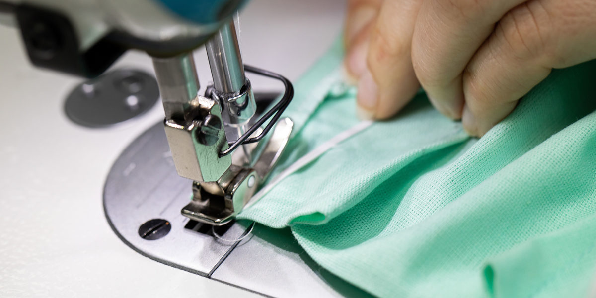 Each piece of fabric has to go through the entire production process from design through cutting to sewing. Schlagwort(e): dressmaker, sew, sewing machine, seamstress, needle, at work, hands, female hands, fabric, cotton, tailor, thread, protective mask, manual worker, piecework, wrist, series, workshop, production, profession, textile industry, service plant, stitch, lockstitch, feeder, table, exactly, fingers, nails, cleanliness, woman, industry, administration, services, machine foot, cotton fabric, handicraft, artist, metal, dust, cuttings, scraps, green, white, studio, rectangle