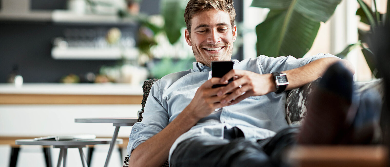 Shot of a happy young man using his cellphone while relaxing on the couch at home Schlagwort(e): Text Message, Real People, Candid, Leisure Activity, One Man Only, Only Men, Young Men, Men, Males, Comfortable, Copy Space, Weekend Activities, Adults Only, Domestic Life, Reclining, Message, Young Adult, Adult, Smiling, Sitting, Looking, Holding, Caucasian Ethnicity, One Person, Relaxation, Carefree, Enjoyment, Happiness, Part Of, Technology, Lifestyles, Indoors, Cheerful, Positive Emotion, Recreational Pursuit, Brown Hair, People, Living Room, Home Interior, Internet, Mobile Phone, Casual Clothing, Sofa
